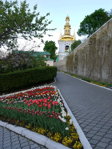 Güzel bir kilise kilise uzakta karşı çok renkli lale ile üçgen flowerbed — Stok fotoğraf