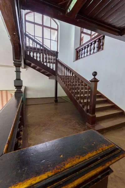 Escadaria de madeira velha bonita com corrimãos ornamentais que conduzem aos andares superiores da casa — Fotografia de Stock