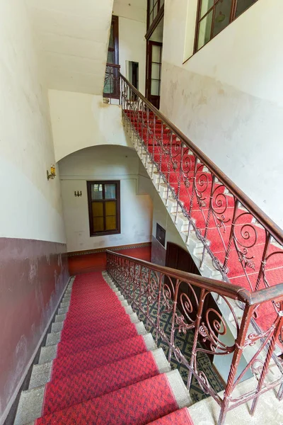 レッド カーペットと床との間の建物の階段のフライト。塗られた壁とそれらの燭台のシャンデリア. — ストック写真