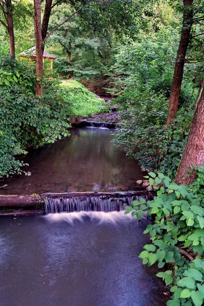 Un gazebo en bois confortable dans le fond d'un canal de rivière décoratif — Photo