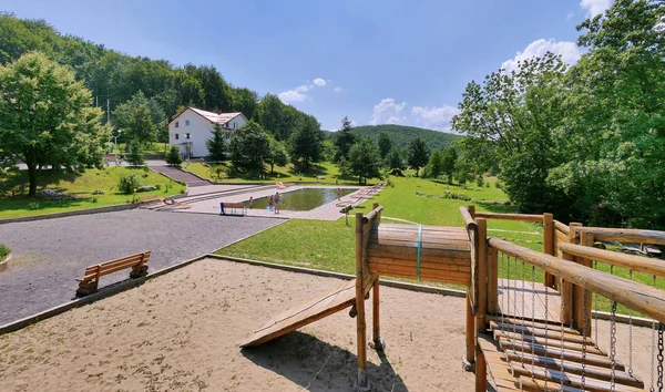 Dětské hřiště od dřeva u bazénu v rekreačním komplexu nedaleko pohoří — Stock fotografie