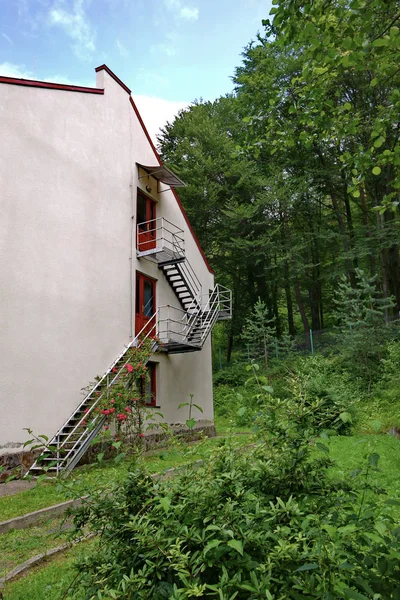 Der rückwärtige Eingang zum dreigeschossigen Gebäude von der Seite des grünen Parks — Stockfoto