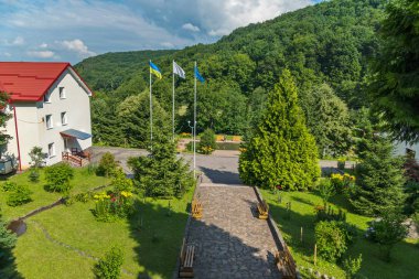 Dağları arasında otelin yakınlarında yükseltilmiş bayrakları ile güzel bir avlu penceresinde göster