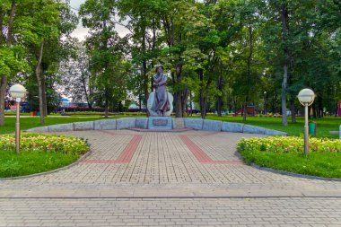 Dekoratif çiçek yatak ve iki tarafta fener park ortasında bronz anıt