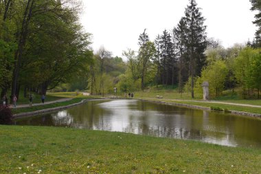 İnsanlar güzel bir şeffaf gölün ortasında dolu caddelerde gezinirler.
