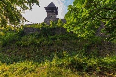 Hisar/kale kule ile yeşil çim büyümüş, eski bir taş duvar arka plan üzerinde
