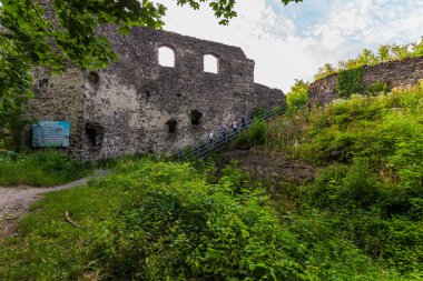 Turistler neredeyse zaman ve hava tarafından yok eski bir kalenin duvarları yakınında merdivenleri.