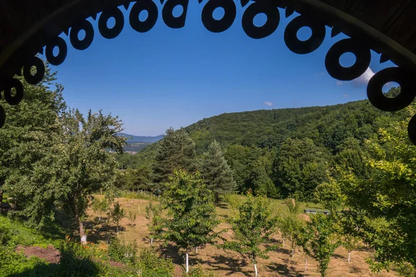 A magnificent view of the mountains under a blue cloudless sky from under the roof of a gazebo made in the form of an arch — Stock Photo, Image