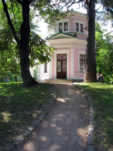 분홍색 벽과 건물에 지도 하는 양쪽에 두 개의 거 대 한 나무와 가파른 경로 — 스톡 사진