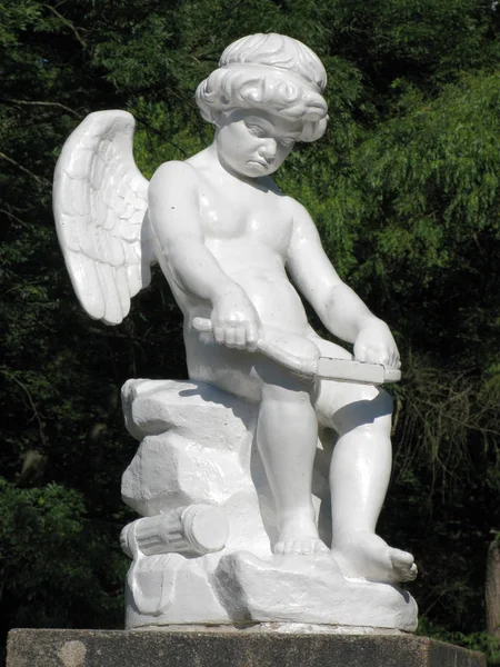 Weiße Statue eines Engels mit kleinen Flügeln, mit Arbeit beschäftigt — Stockfoto