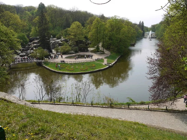 Breiter Wasserkanal mit Springbrunnen. Um sie herum gibt es Paare mit grünen Blumenbeeten, von denen eine zweihundertdreizehn Blüten hat. — Stockfoto