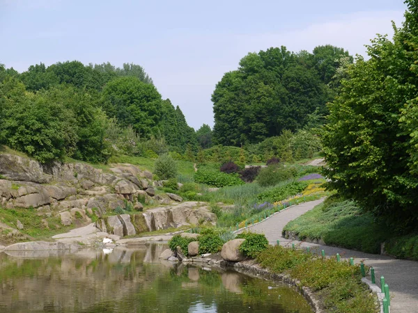 Ein kleiner Teich im Park. Es gibt große Felsbrocken ringsum — Stockfoto