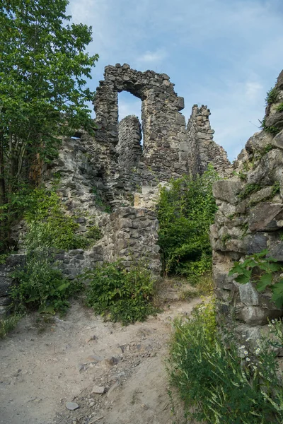 De antika ruinerna av det gamla slottet är övervuxna med gräs och buskar med stenar som fallit från tid och väder från väggarna. — Stockfoto