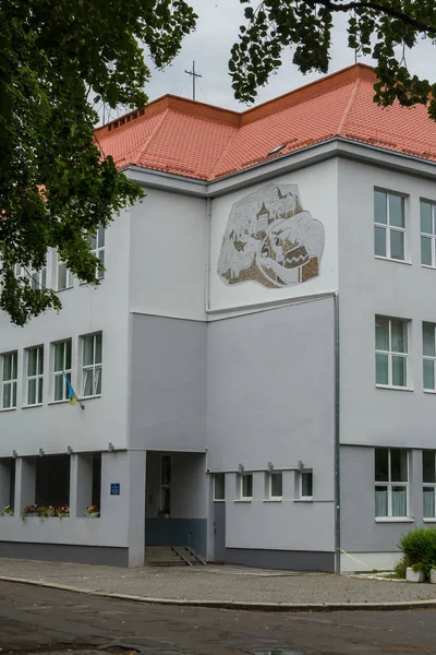 Une photo sur le mur d'un bâtiment avec un toit carrelé et un drapeau du pays sur un mât de drapeau — Photo