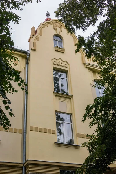 Fasada budynku na tle zielonych liści — Zdjęcie stockowe