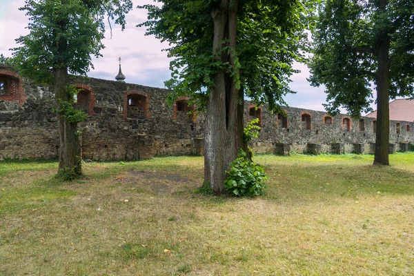 En stor sten försvarsmur med toppen av den kyrkliga kyrkan i bakgrunden — Stockfoto