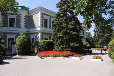 turistler parkta kendilerini uzun boylu çalılar ve çiçekler ile renkli çiçek yatak arka karşı çekim