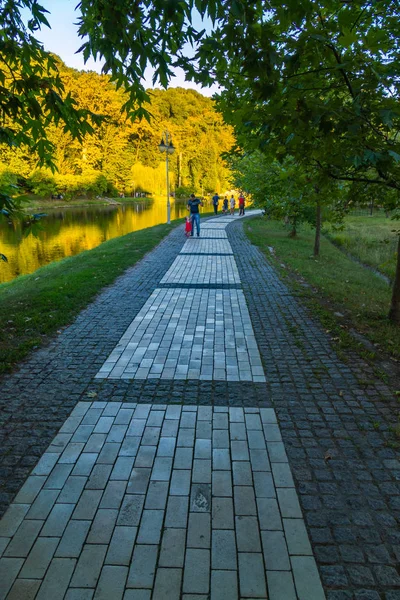 Ruelle pavée de tuiles multicolores sur le rivage d'un grand lac décoratif transparent — Photo