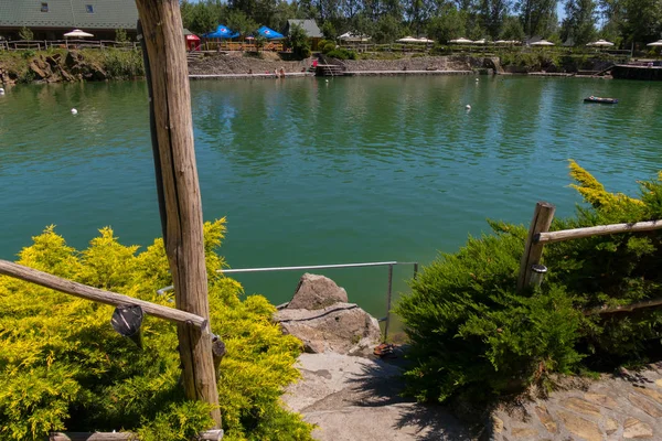 Una pintoresca vista de una montaña decorativa lago claro con la natación y tomar el sol turistas —  Fotos de Stock