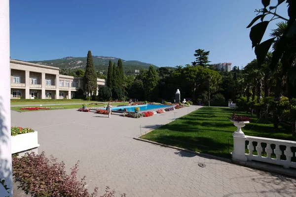 Belle vue sur la piscine dans le parc avec de belles fleurs autour et les touristes prenant des photos sur le fond de toute cette splendeur . — Photo