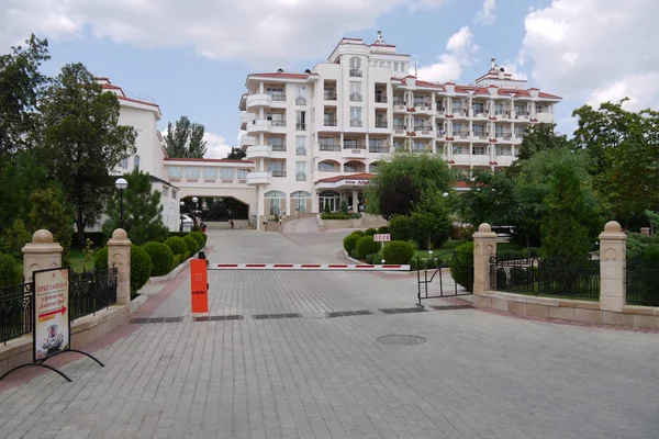 A paved road leads to a representative hotel with a barrier blocking the gates — Stock Photo, Image