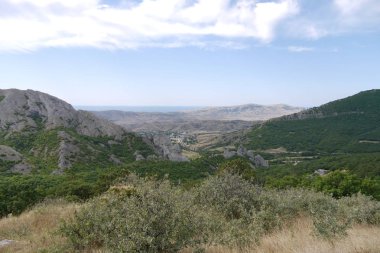 Dağlık arazi dağ tepeler ve vadiler yeşil orman kaplı ve tek bir ağaç olmadan tamamen çıplak bir manzara.