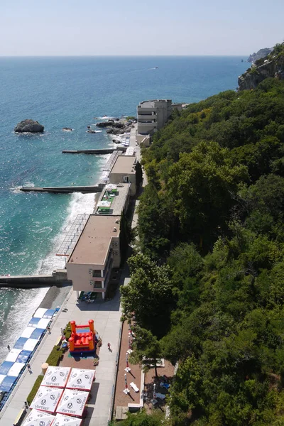 Ένα μεγάλο ανάχωμα με ύφαλα για τουρίστες, εστιατόρια, παιδικές χαρές παιδική και αποβάθρες στο φόντο βουνά και το γαλάζιο της θάλασσας — Φωτογραφία Αρχείου