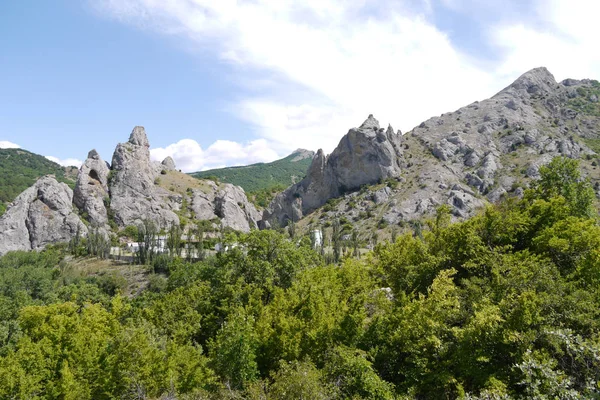 Krajina bodlinatý kamenné kopců s osadou v údolí mezi nimi — Stock fotografie