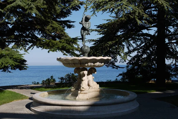 Fuente niño con un pez de cedro alto sobre el fondo del mar azul sin límites — Foto de Stock