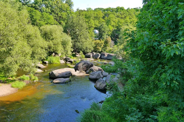 Široká řeka rocky obklopených krásnou vzrostlými stromy — Stock fotografie