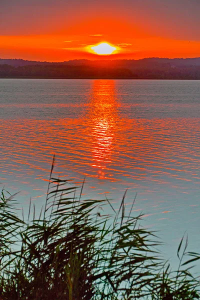 Weite ruhige See vor dem Hintergrund eines wunderschönen Feueruntergangs — Stockfoto