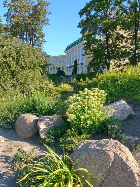 Bela natureza com flores brilhantes crescendo ao lado do hotel localizado em um longo edifício com bela arquitetura . — Fotografia de Stock