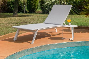 Havuzun yanında güneş lounge.