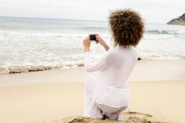 美丽的女孩与非洲头发和白色礼服拍照与智能手机 — 图库照片