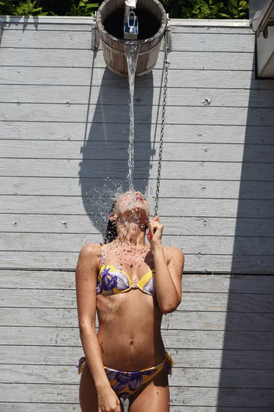 Schöne Mädchen bekommen kühle Wasserdusche im Sommerurlaub — Stockfoto