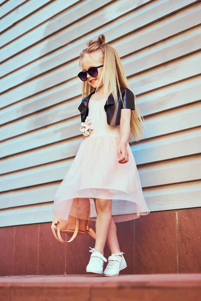 Yaşam tarzı şık küçük kız Genç portresi. Siyah ceket, pembe etek giyen güzel çocuk. Güzel uzun saçları.