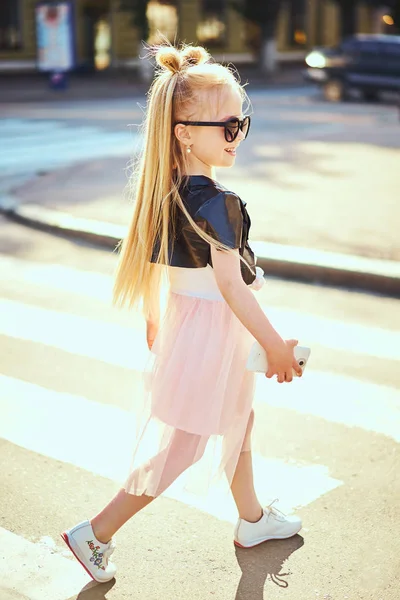 Küçük kız çocuğu alarak kendi kendine resim portre renkli arka plan üzerinde şehirde Smartphone