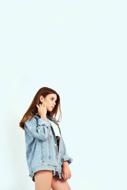 Beyaz bir arka plan üzerinde stüdyoda poz beyaz bir T-shirt ve jeans giysiler içinde güzel bir model. Yaşam tarzı, moda, güzellik