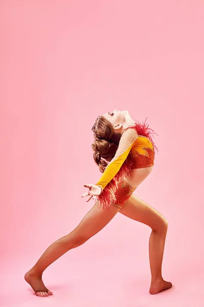 Contemporary dance. A little girl performs a complex acrobatic dance. Modern dance on a bright colorful background.