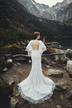 Dağlarda bir göl yakınında güzel bir gelin yürür