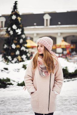 Modeli şık sıcak giysiler giyiyor. Sokakta poz güzel mutlu gülümseyen kız. Noel, yeni yıl, kış tatil kavramı. Şehir yaşam tarzı