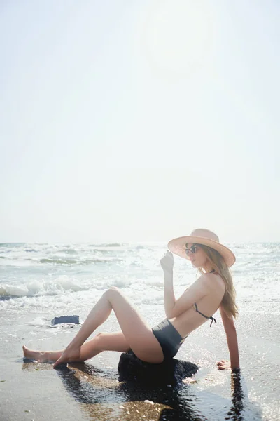 享受生活 微笑着躺在热带岛屿的海滩上 穿着时尚的比基尼 太阳镜和宽边帽 美丽年轻的晒黑模型的夏季生活方式肖像 — 图库照片