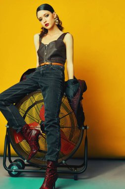 Kırmızı arka planda şık kıyafetler içinde poz veren genç ve güzel bir manken. Moda, şık kıyafetler, aksesuarlar, güzellik