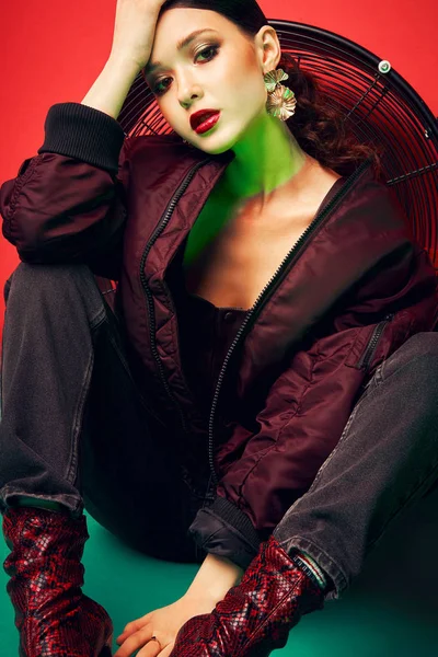 Joven modelo hermoso posando en ropa elegante sobre un fondo rojo. Moda, ropa elegante, accesorios, belleza — Foto de Stock