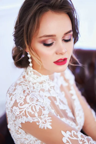 Красивая невеста в платье позирует в студии на цветном фоне. Магазин свадебных платьев, свадебный макияж, шикарная прическа, витрина магазина — стоковое фото