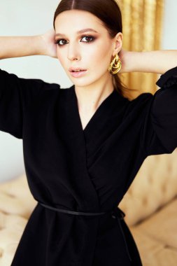 Güzel model, zarif gece elbisesi moda fotoğraf. Stüdyoda poz veren kadın, makyaj, altın küpe, topuklu ayakkabı. Şık giysiler, bir bayan için nazik bir görüntü