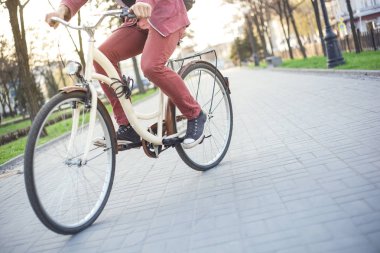 Kırmızı kot pantolon ve spor ayakkabı Mall bej bisikletle bir erkekte
