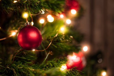 Çelenk ahşap duvar arka plan üzerinde kırmızı Noel top bir Noel ağacı üzerinde