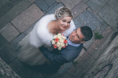 Gelin damat parkta elbiseli sarılma beyaz gül buketi ile beyaz bir gelinlik