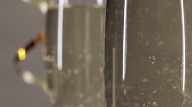 Altın bir şerit ile gri bir arka plan üzerinde bir bardak şampanya kabarcıklar yükselişi